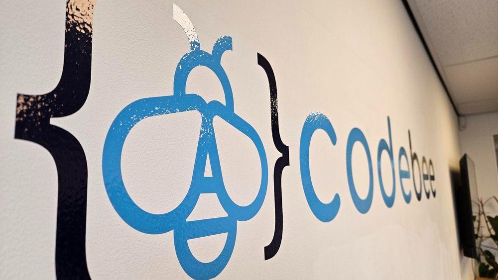 CodeBee logo op muur
